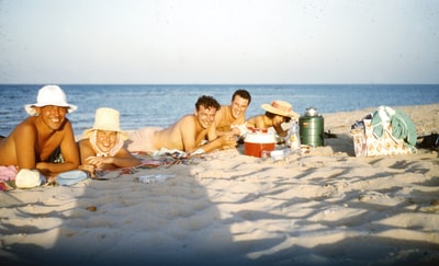 3名妇女白天坐在靠近水体的沙滩上